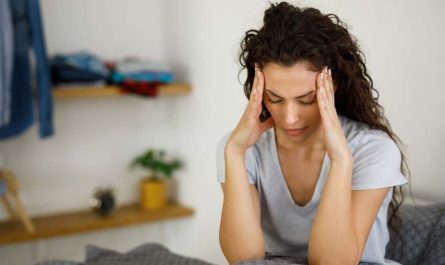 Woman in bed suffering from headache